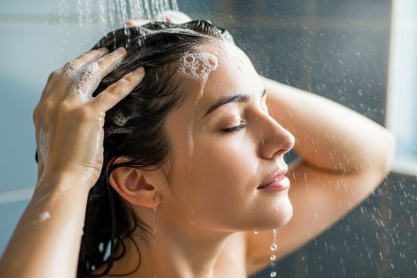 Mulher cuidando do couro cabeludo em rotina capilar simples para queda